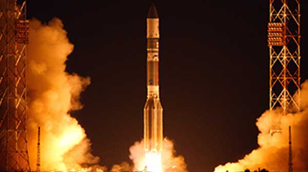 Image of rocket launch on launch pad with fire building just before take off