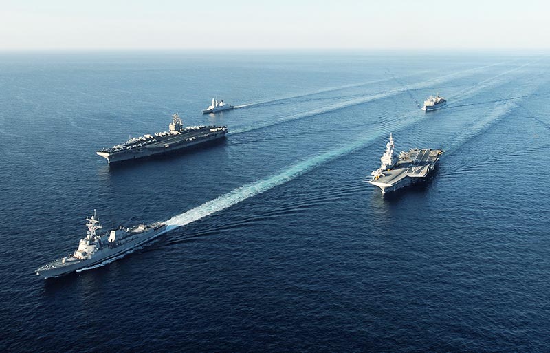 Five U.S. military ships travelling across ocean
