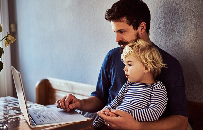 Father and son using laptop together