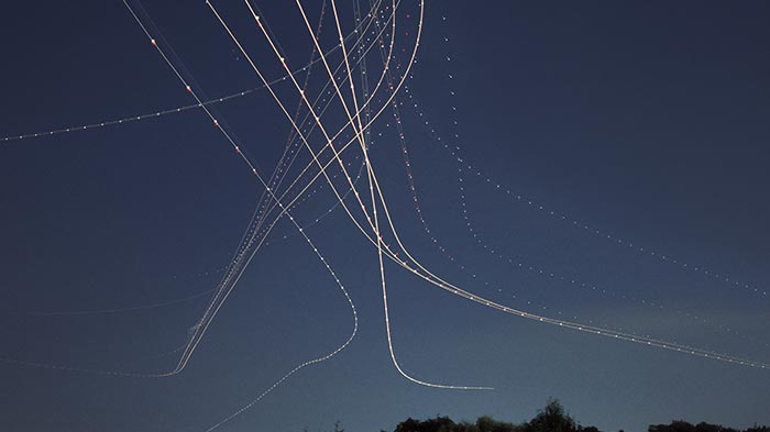 night sky with strings of airplane exhaust