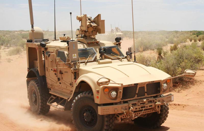 army vehicle in driving on desert road