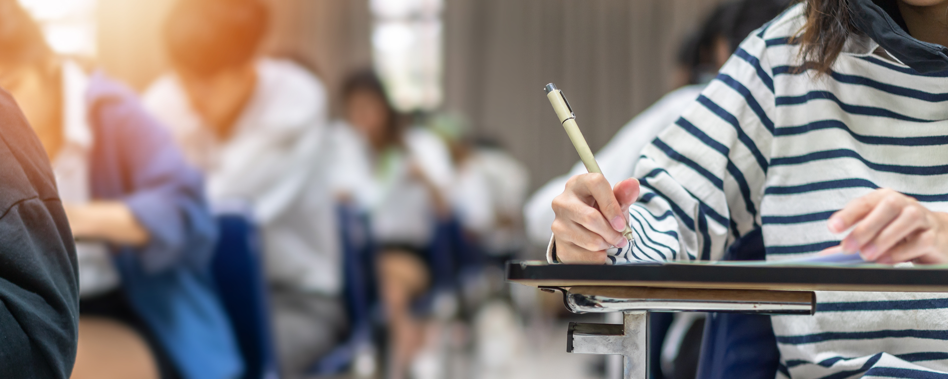 classroom image with close up view of student writing