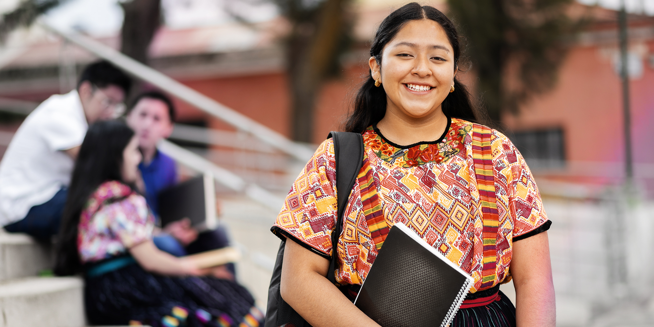 Portrait of an indigenous college student with books in hands in the university
