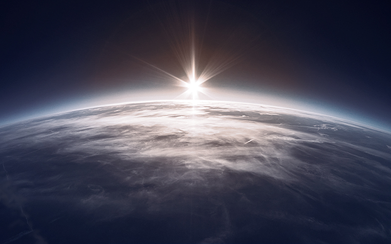 space view of earth with the sun coming up on horizon