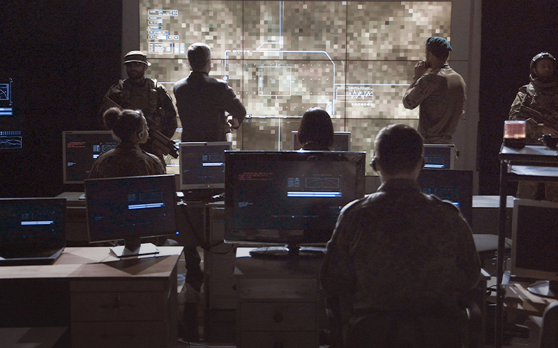 people in mission control room sitting in front of monitors