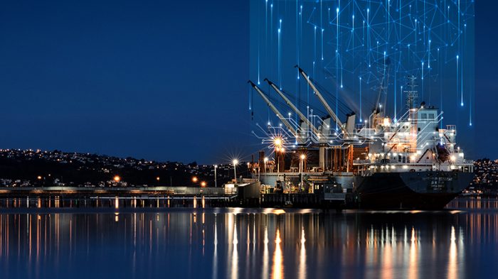 "Large illuminated ship docked at night, with glowing light trails rising into the dark sky, representing satellite links and global maritime connectivity.