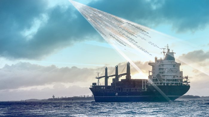 container ship at sea with beam from the sky indicating data going to & from ship