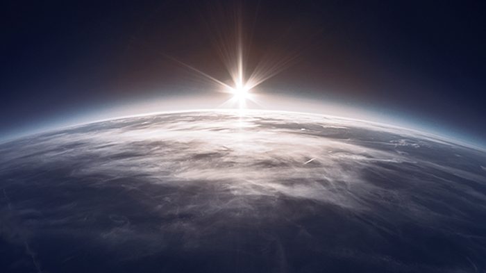 space view of earth with the sun coming up on horizon