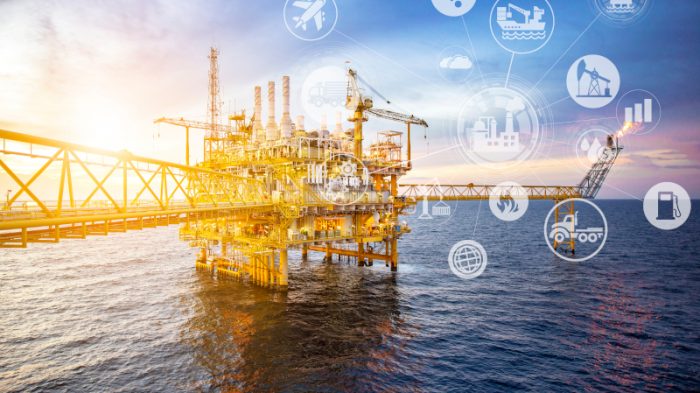 Offshore oil and gas platform with digital connectivity icons representing satellite communications for remote energy operations