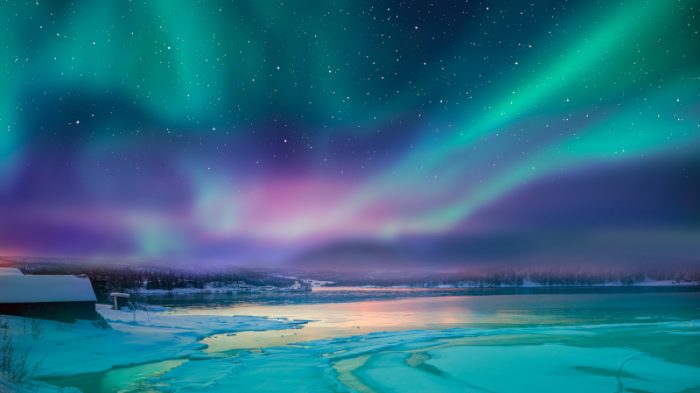 Borealis northern lights illuminating a frozen Nordic landscape under a starry night sky.