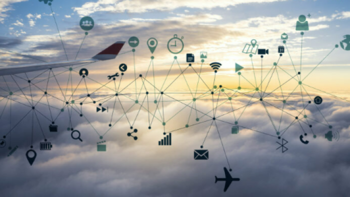 Airplane wing above clouds. Varios icons and lines are around the plane to connote onboard applications like Wi-fi, retail shopping and email